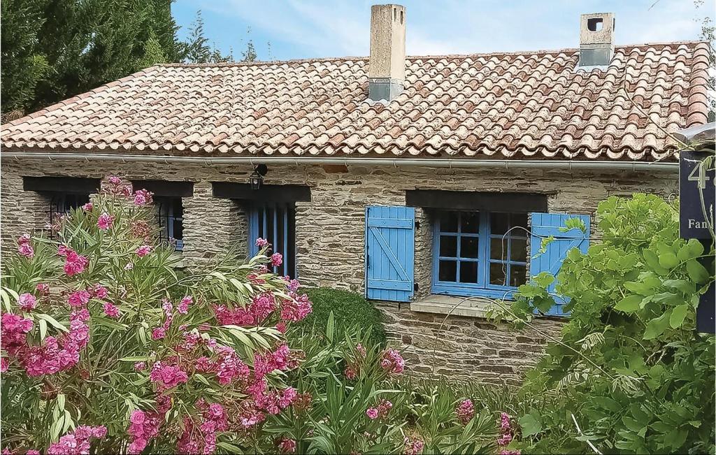 an old stone house with blue windows and flowers at Awesome Home In Lamalou Les Bains in Lamalou-les-Bains