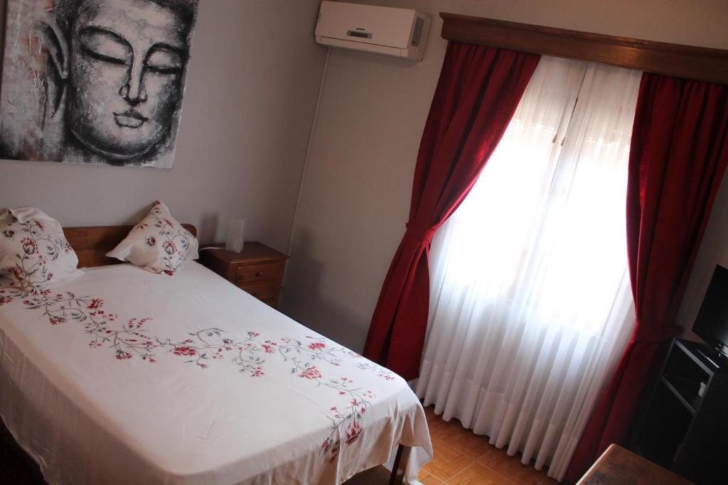 1 dormitorio con 1 cama y una ventana con cortinas rojas en Restaurante Abba, en Póvoa de Lanhoso