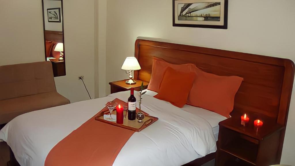 Hotel Madrigal في بورتوفيخو: غرفة فندق بسرير مع صينية عليها شماعات