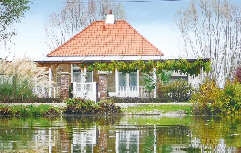 a house sitting on top of a body of water at Pet Friendly Home In Houlle With Kitchen in Houlle