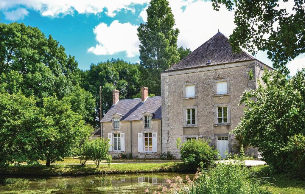 une ancienne maison en pierre avec un étang en face de celle-ci dans l'établissement Beautiful Apartment In Baccon With Wifi, à Baccon