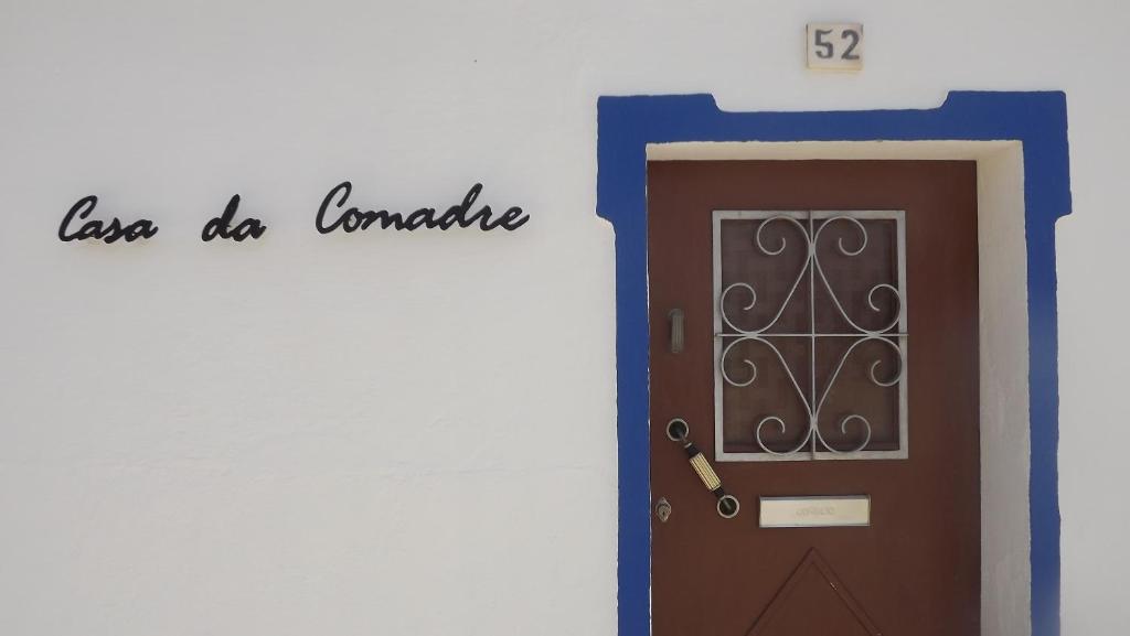 a door with a sign that reads love do romance at Casa da Comadre - Casas de Taipa in São Pedro do Corval