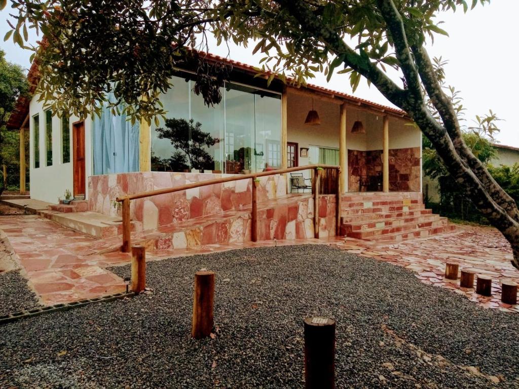 a building with a tree in front of it at Casa com Vista para Montanhas - C Diamantina in Palmeiras