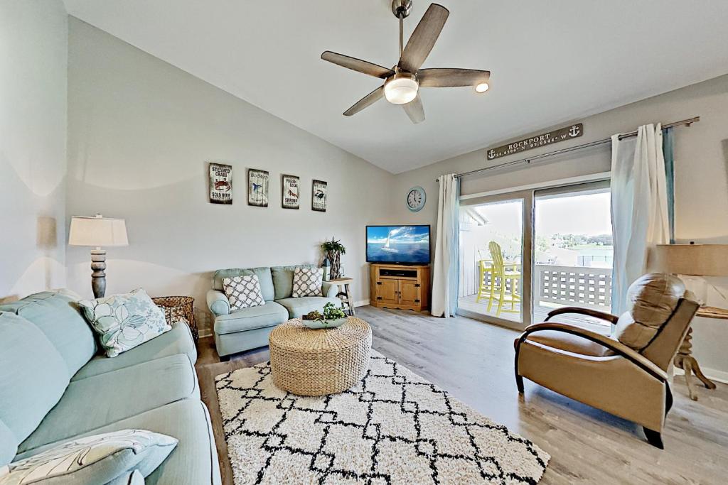 a living room with a blue couch and a ceiling fan at Bayhouse condos 2410 in Rockport
