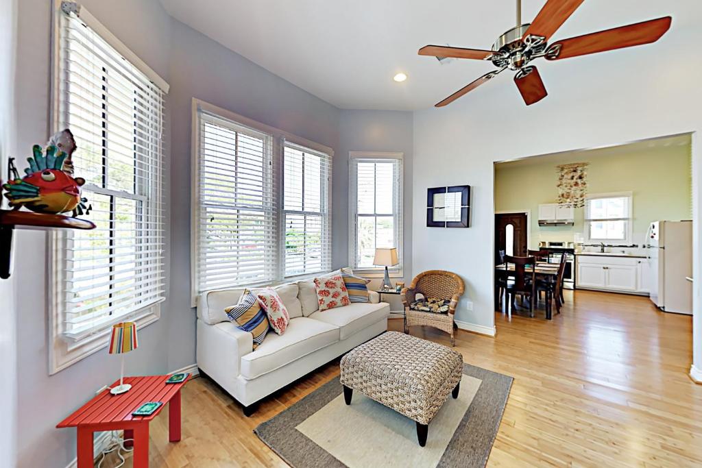 a living room with a couch and a ceiling fan at Under the Avenue in Galveston