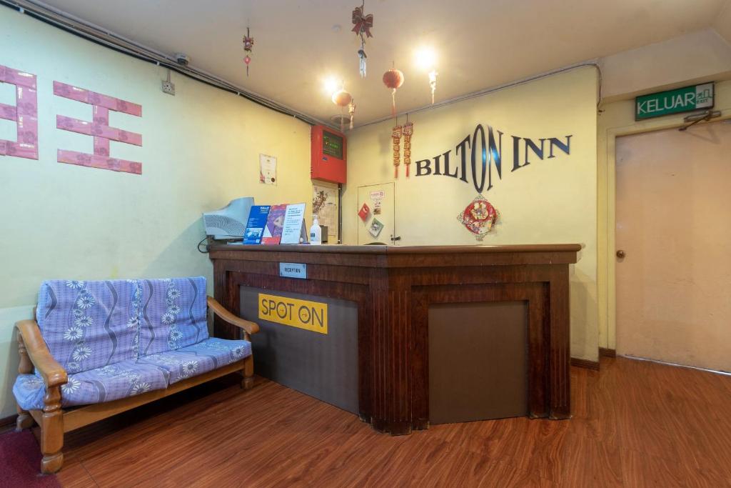 una sala de espera con una silla azul y un podio en OYO 89625 Bilton Inn, en Kota Kinabalu