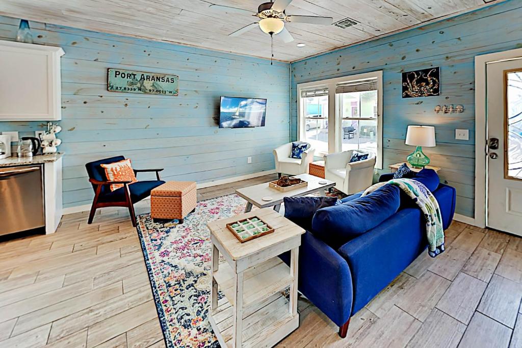 a living room with blue walls and a blue couch at Coral Cove in Port Aransas