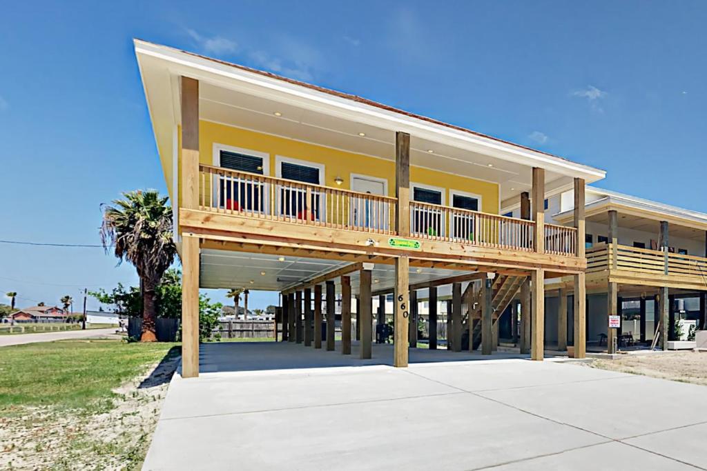 a large yellow house with a large deck at Beautiful Sea in Port Aransas