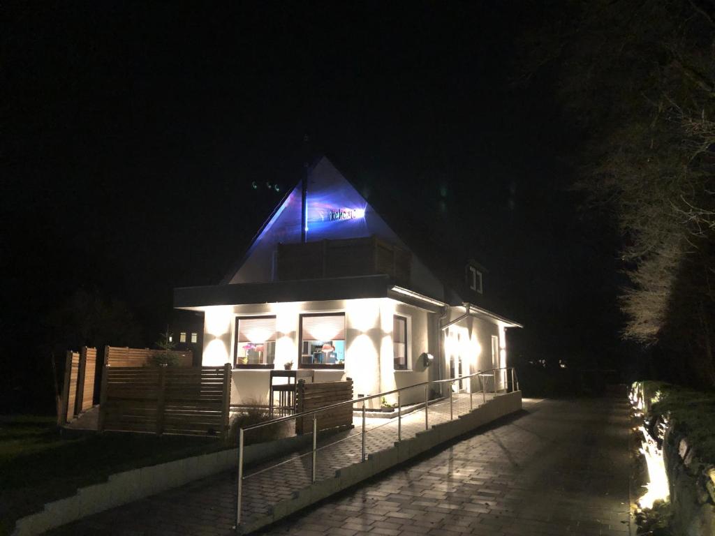 a house with a lit up roof at night at likehome Apartment in Buchholz in der Nordheide