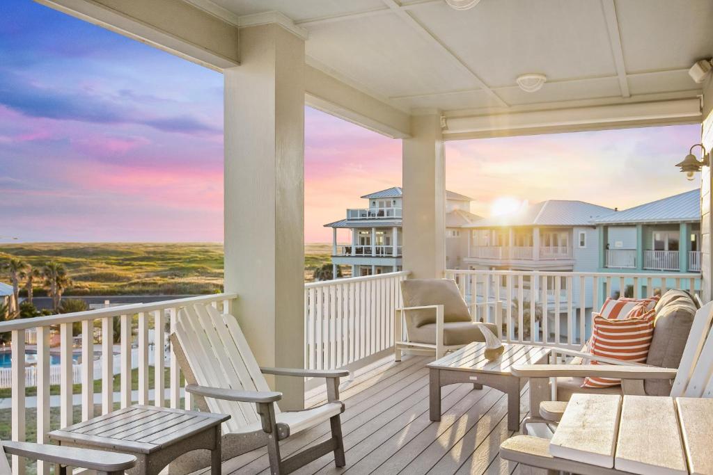 - une terrasse couverte avec des chaises et des tables et une vue sur l'océan dans l'établissement Salty Kisses, à Île Padre
