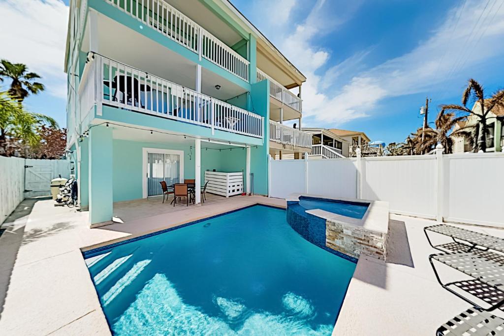 a swimming pool in front of a house at Island Escape & Huisache Townhome in South Padre Island