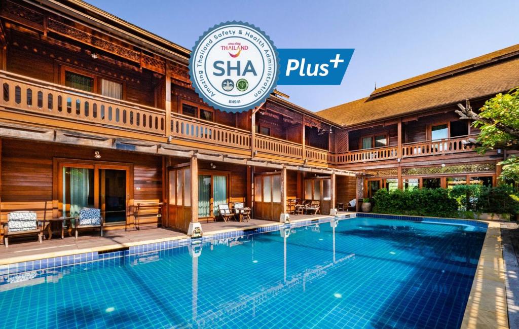 a hotel swimming pool in front of a building at Baan U Sabai Boutique House-SHA Plus in Chiang Mai