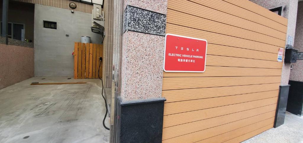 ein Schild an der Seite eines Gebäudes mit einer Tür in der Unterkunft 煙燻貓民宿 tesla充電需電洽-無合作Ago達平台 in Taitung