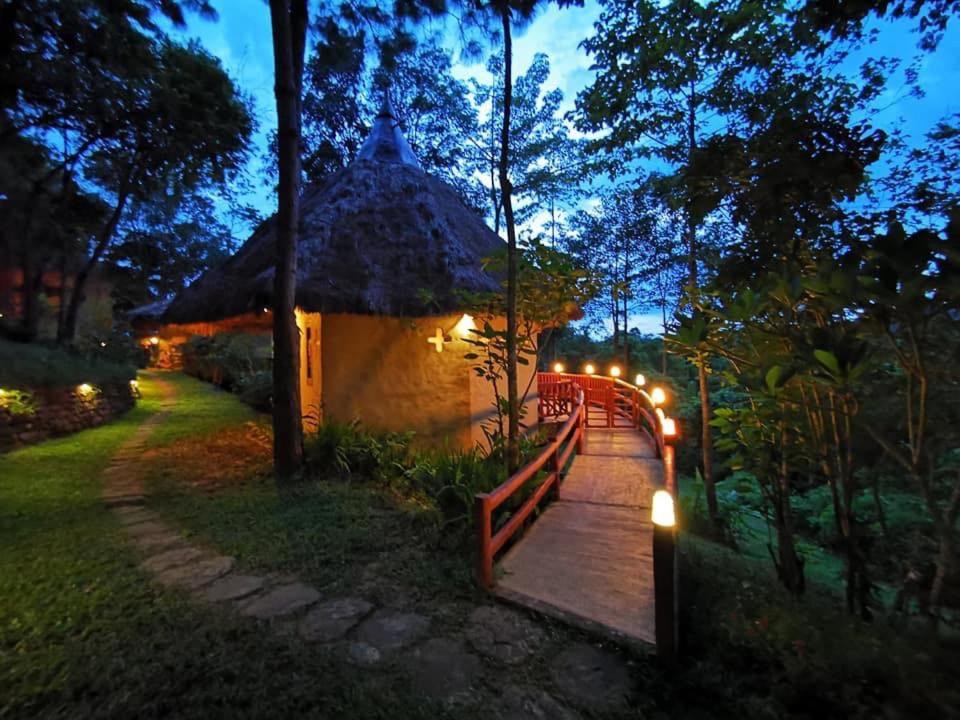 a wooden bridge leading to a hut with lights at สะเลเต ชาเล่ต์ 