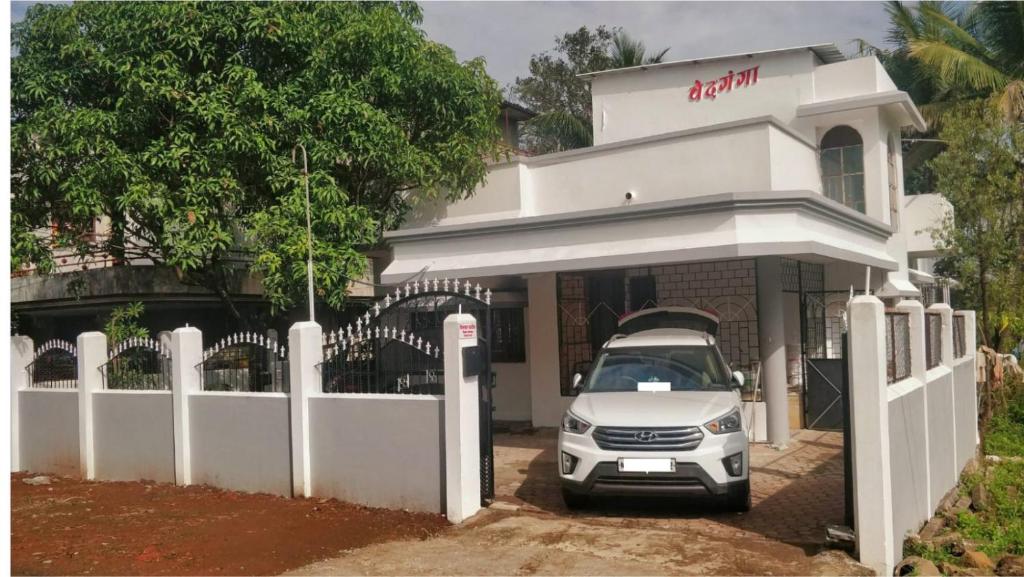 un coche blanco estacionado frente a un edificio en Vedganga Villa - Homestay, en Kolhapur