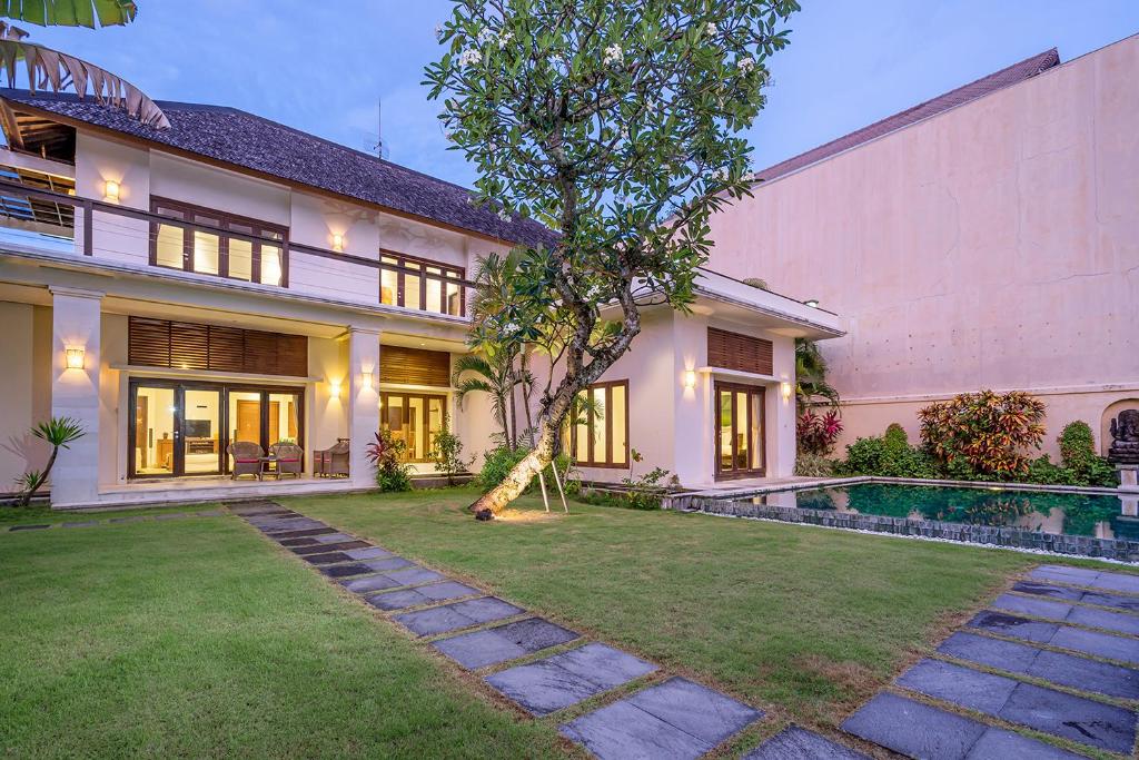 an exterior view of a house with a swimming pool at Bali Villa Lotus in Seminyak