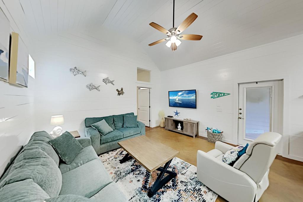 ein Wohnzimmer mit einem Sofa und einem Tisch in der Unterkunft Mermaid Cove at Pirate's Bay unit 209 in Port Aransas