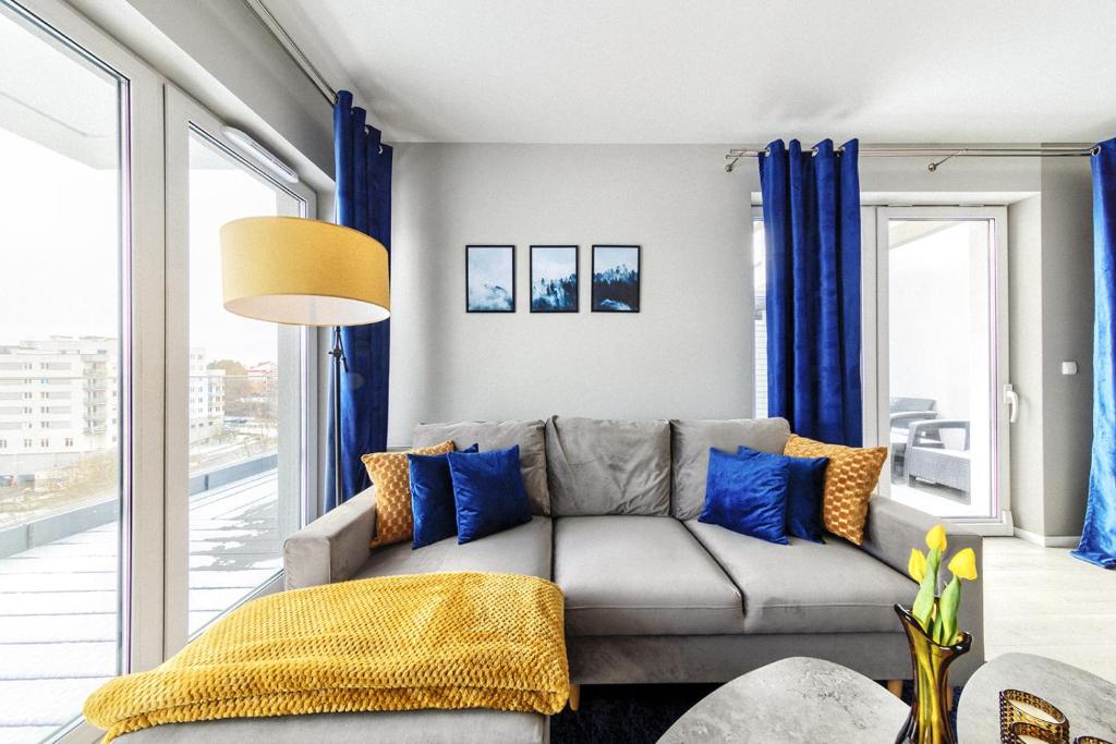 sala de estar con cortinas azules y sofá en Tarasowy Apartamenty Luksusowe en Olsztyn