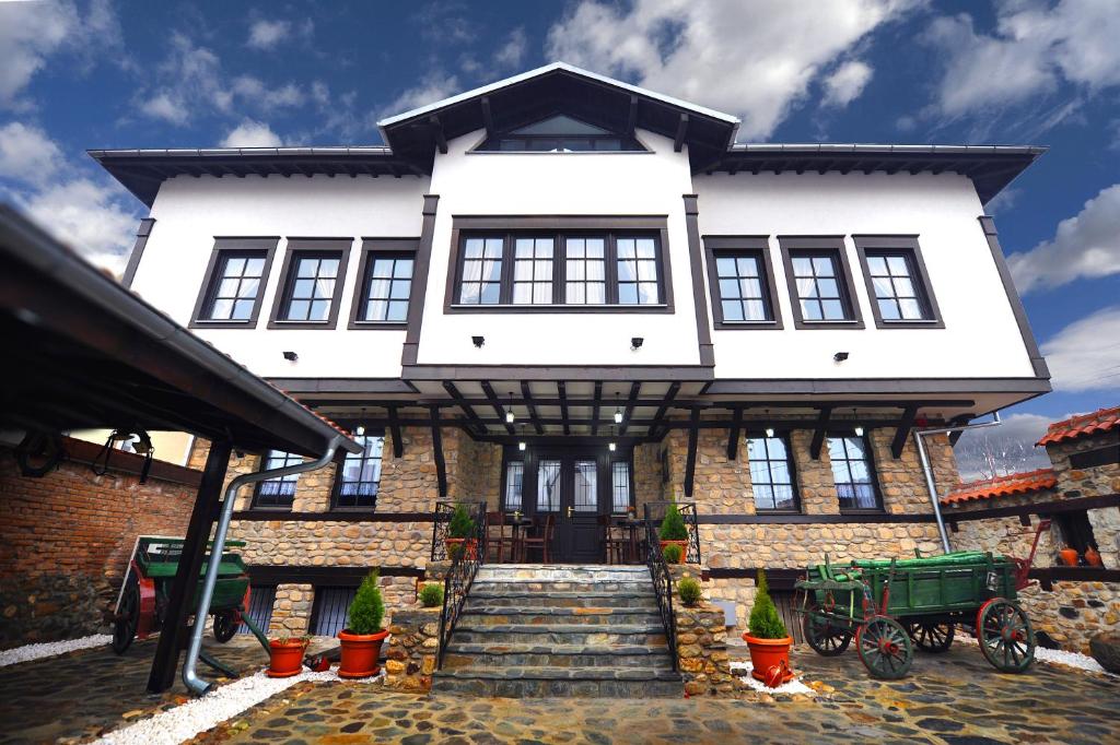 a large white house with stairs in front of it at Hotel Theatre in Bitola