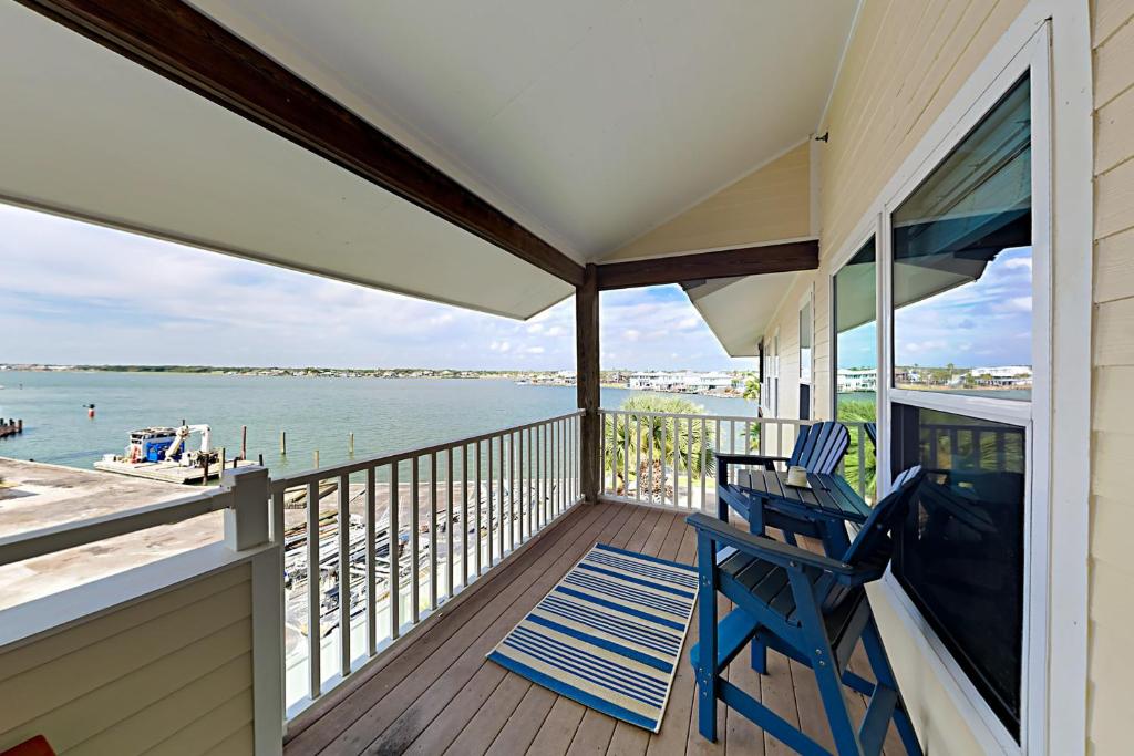 a porch with two chairs and a view of the water at Sand Dollar Unit C3 in Rockport