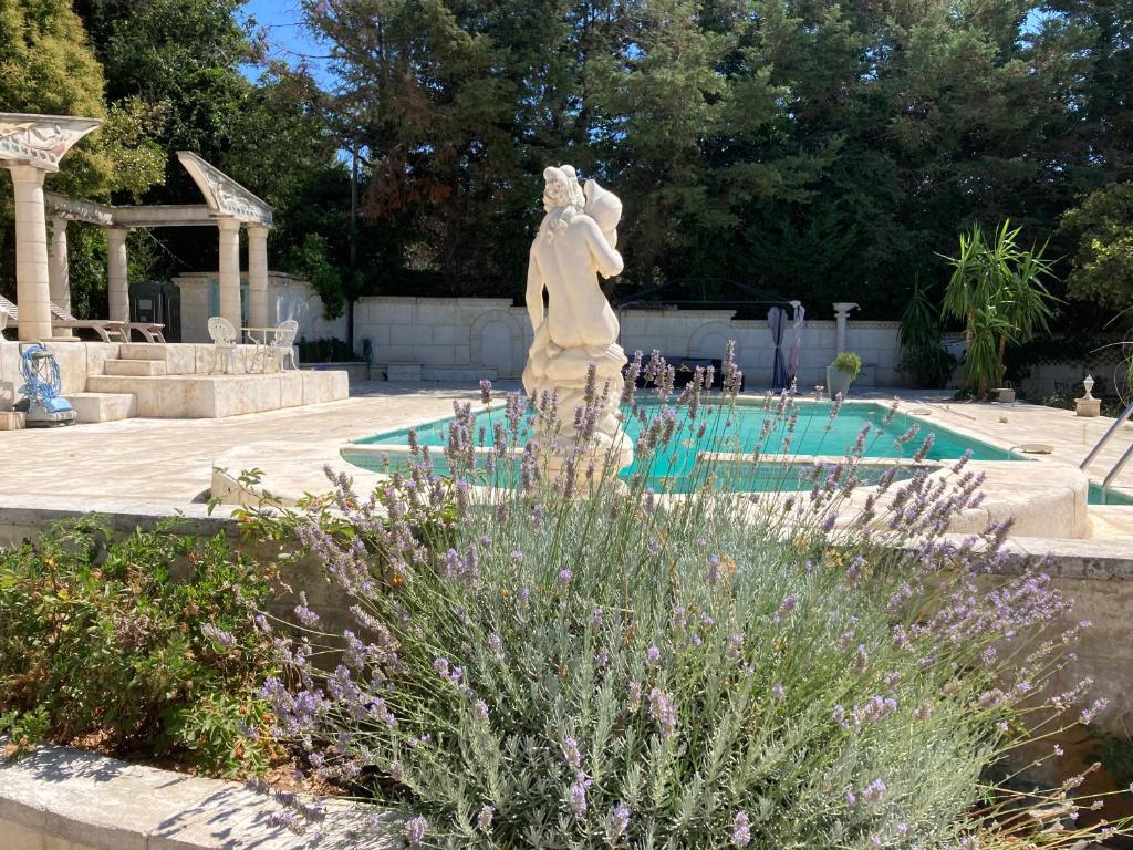 a statue in a garden next to a swimming pool at Gîte Encore Un Soir in Hyères