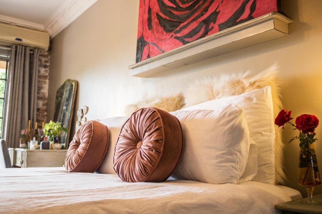 1 cama con 2 almohadas y una pintura en la pared en La Casa Nostra Villa Rose Garden Bella, en Hillcrest