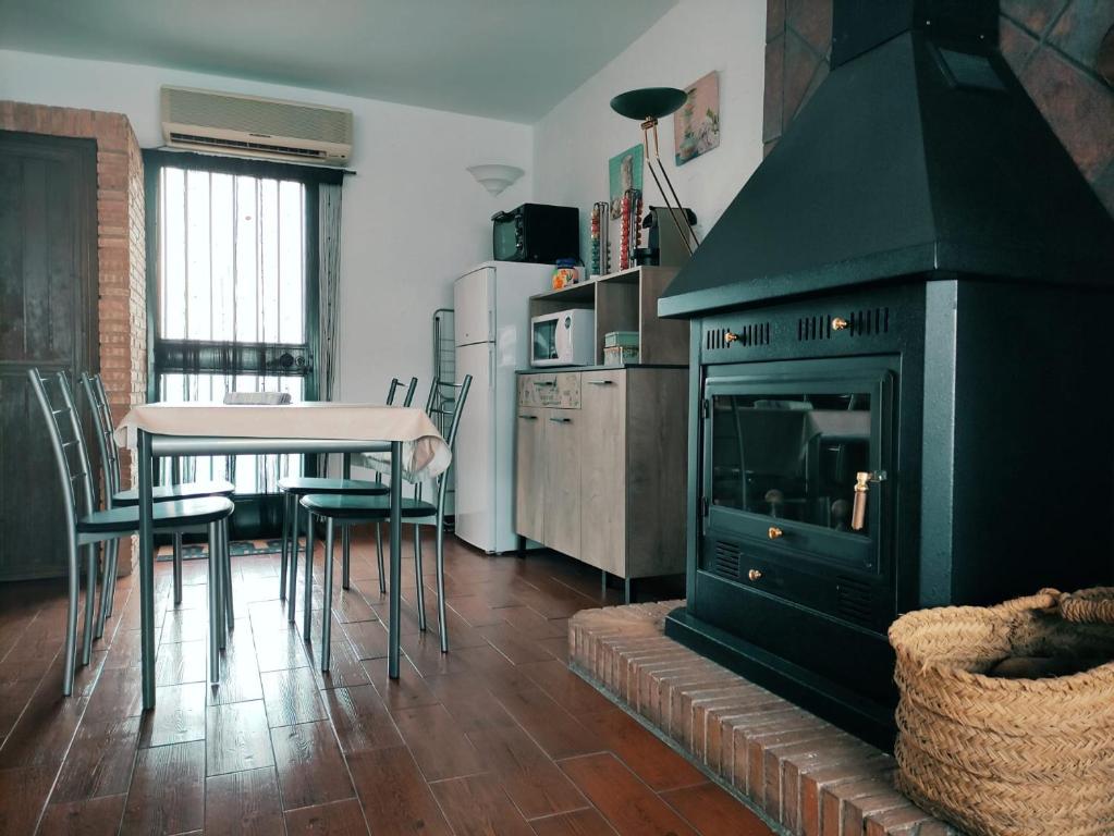 a kitchen with a black fireplace and a table and chairs at La casita del río 2 in Granada