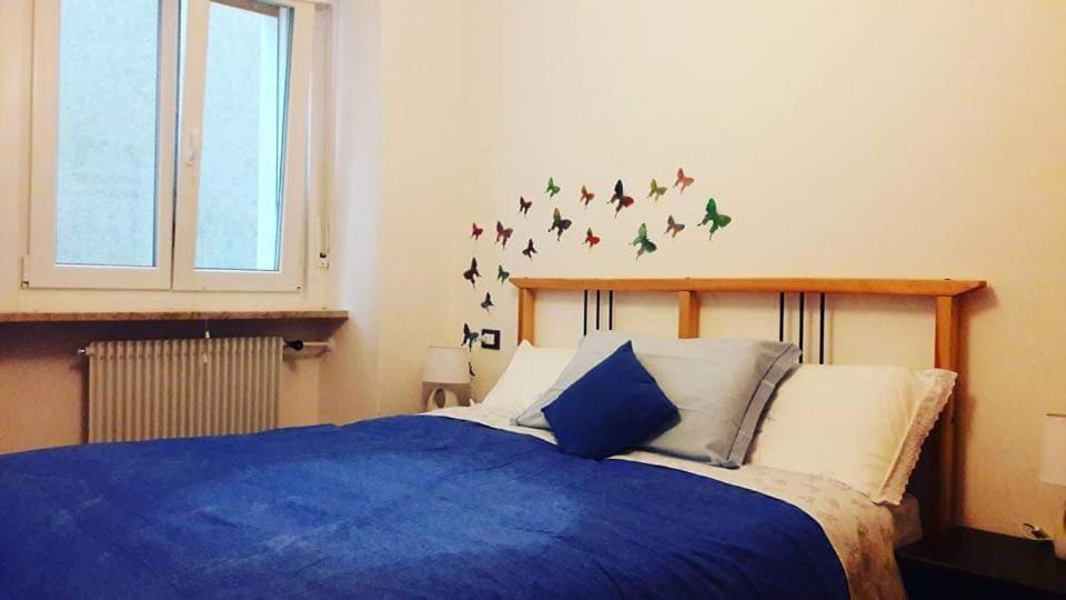 Un dormitorio con una cama azul con pájaros en la pared en Appartamenti Viola, en Cavedago
