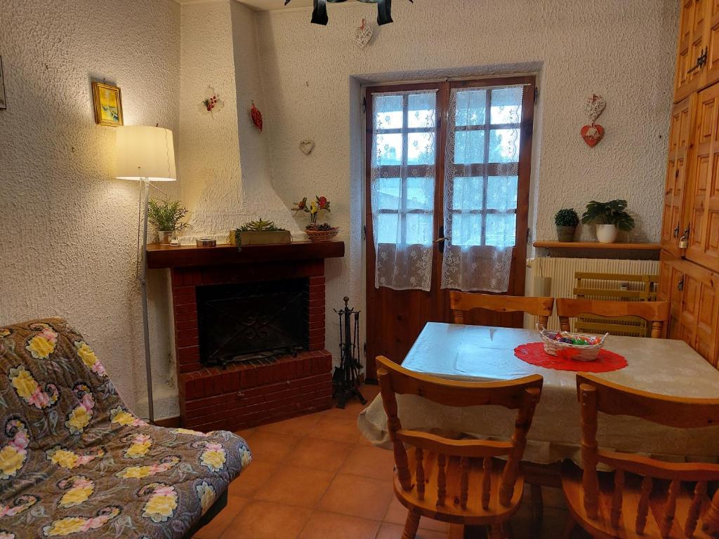 sala de estar con mesa y chimenea en Casa Vittoria, en Rivisondoli