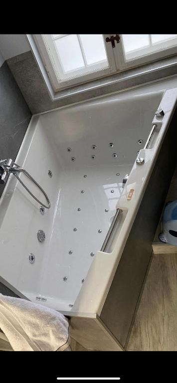 a large bath tub in a room with a window at Sopot, BIG APARTMENT FOR 6!!! Air condition, jacuzzi in Sopot