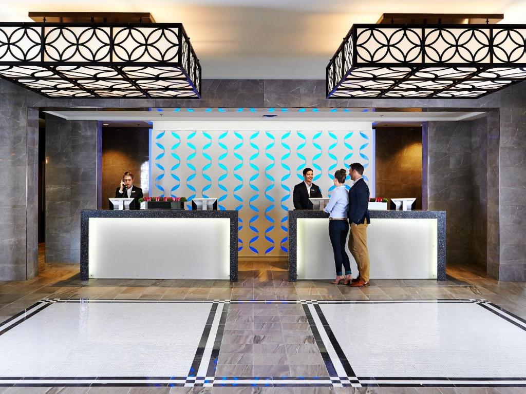 a group of people standing at a counter in a lobby at The Prince George Hotel in Halifax