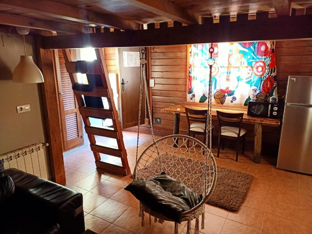 Una sala de estar con una cama alta y una mesa. en Fuente del Lobo Glamping & Bungalows - Adults Only, en Pinos Genil