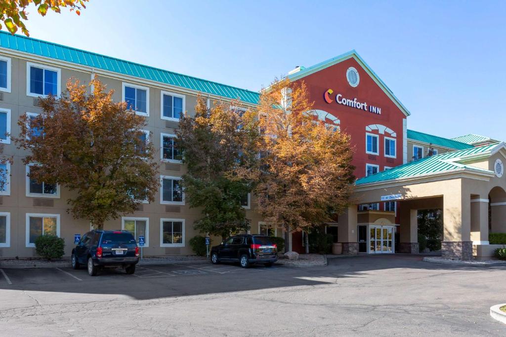 un grupo de edificios con coches estacionados en un estacionamiento en Comfort Inn West Valley - Salt Lake City South en West Valley City