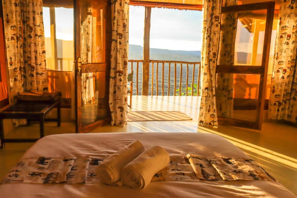 Ce lit se trouve dans un dortoir avec vue sur un balcon. dans l'établissement Maili Saba Camp, à Nakuru