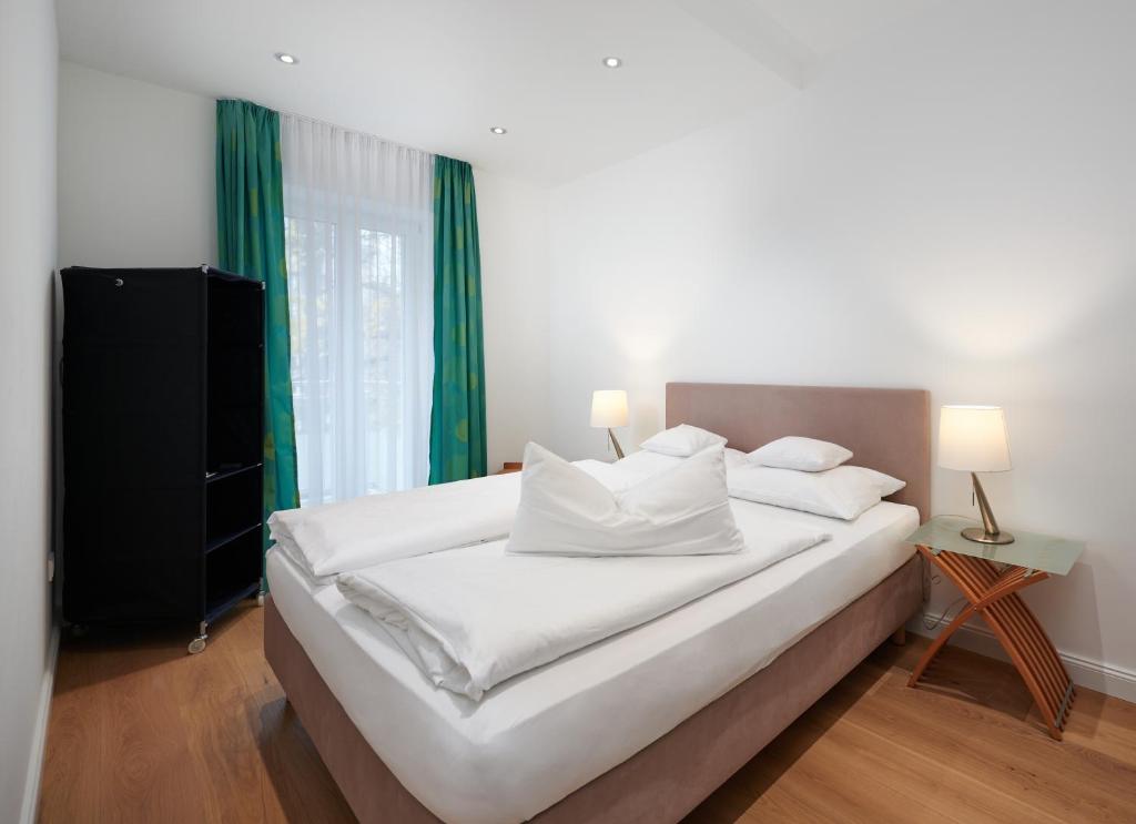 a bedroom with a large white bed with green curtains at 120qm Deluxe Apartment Suites Christina im Stil Design Hotel Vosteen Nähe der Kaiserburg in Nürnberg