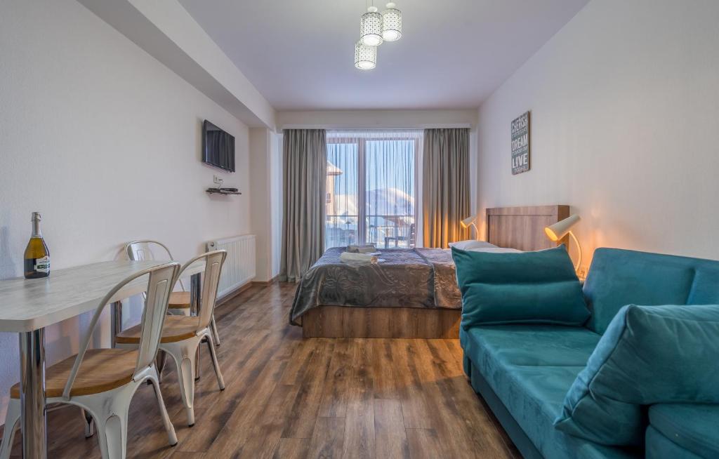 a living room with a couch and a table and a bed at Gudauri Cozy Home in Gudauri