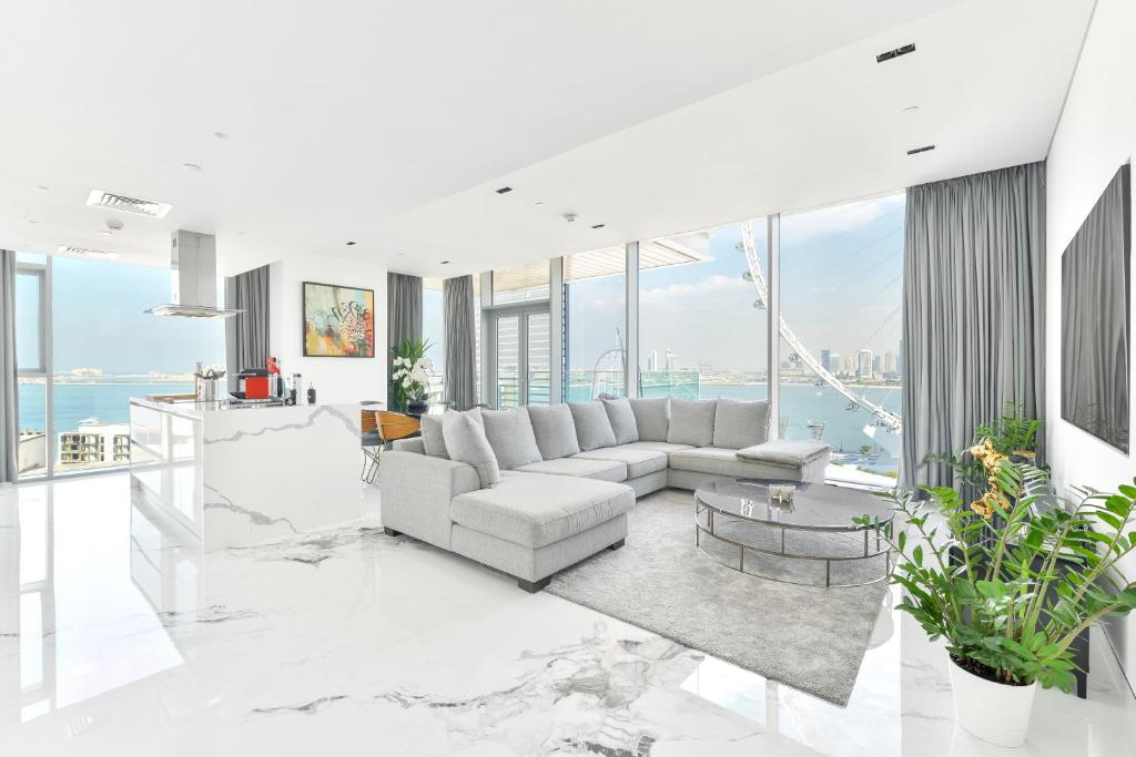 a living room with white furniture and large windows at Luxurious 3 BR w maidroom in BLUEWATERS ISLAND in Dubai