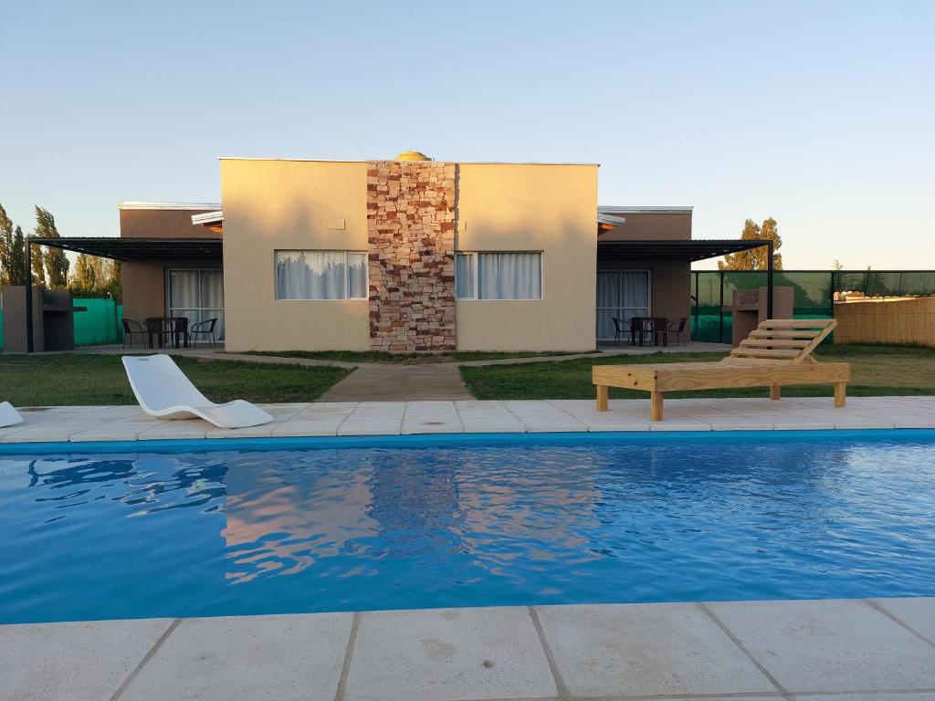 a house with a swimming pool in front of a house at Cabañas Mágico Atardecer in San Rafael