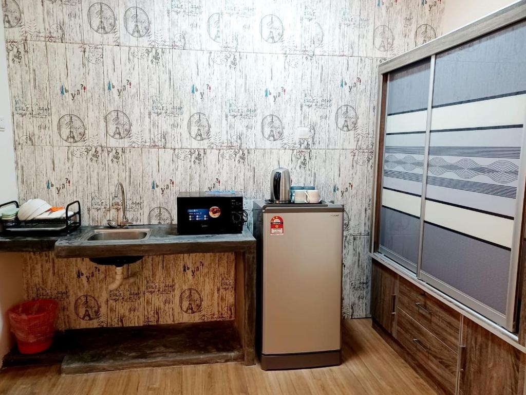uma cozinha com um frigorífico e um lavatório em Saville Cheras Studio Next To Mrt Sri Raya Station em Cheras