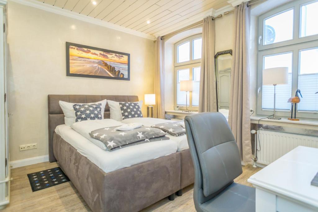 ein Schlafzimmer mit einem Bett und einem Schreibtisch mit einem Stuhl in der Unterkunft Aschenputtel in Westerland