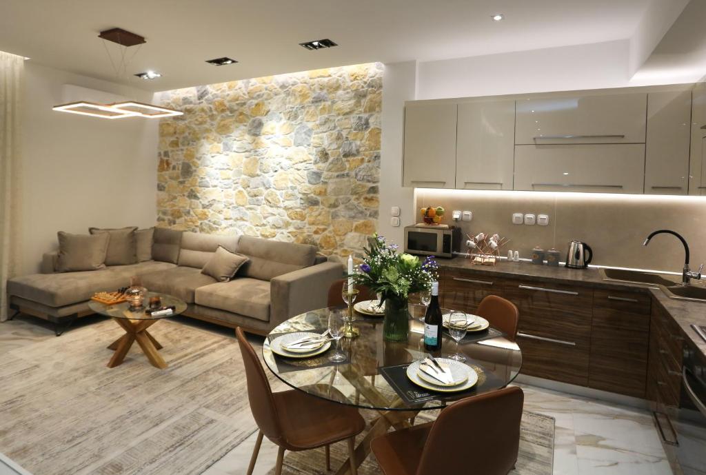 a kitchen and living room with a table and a couch at LA Larissa Luxury Apartments Stelve in Larisa