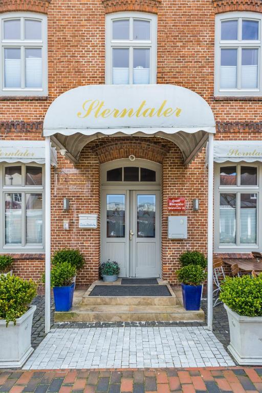 a front door of a brick building with a sign that reads muraler at Schneewittchen in Westerland