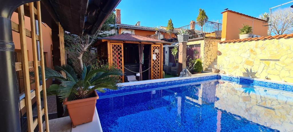 una piscina accanto a un edificio con una casa di Bed & Breakfast Villa Adriana a Premantura