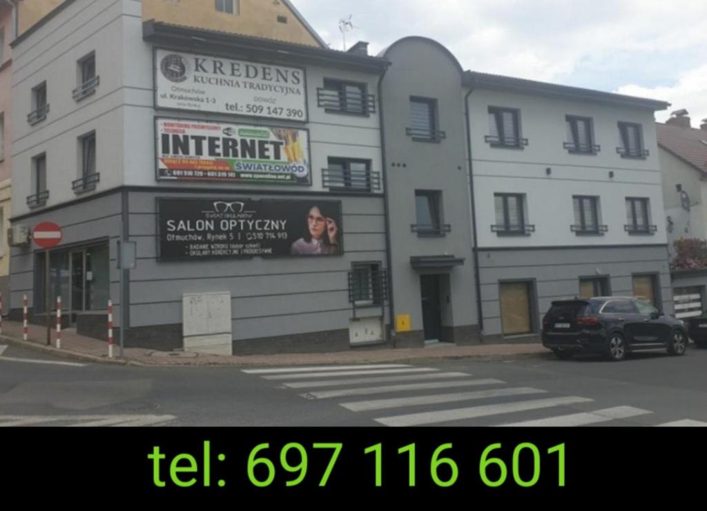 a large white building on a city street at Apartament STYL in Otmuchów