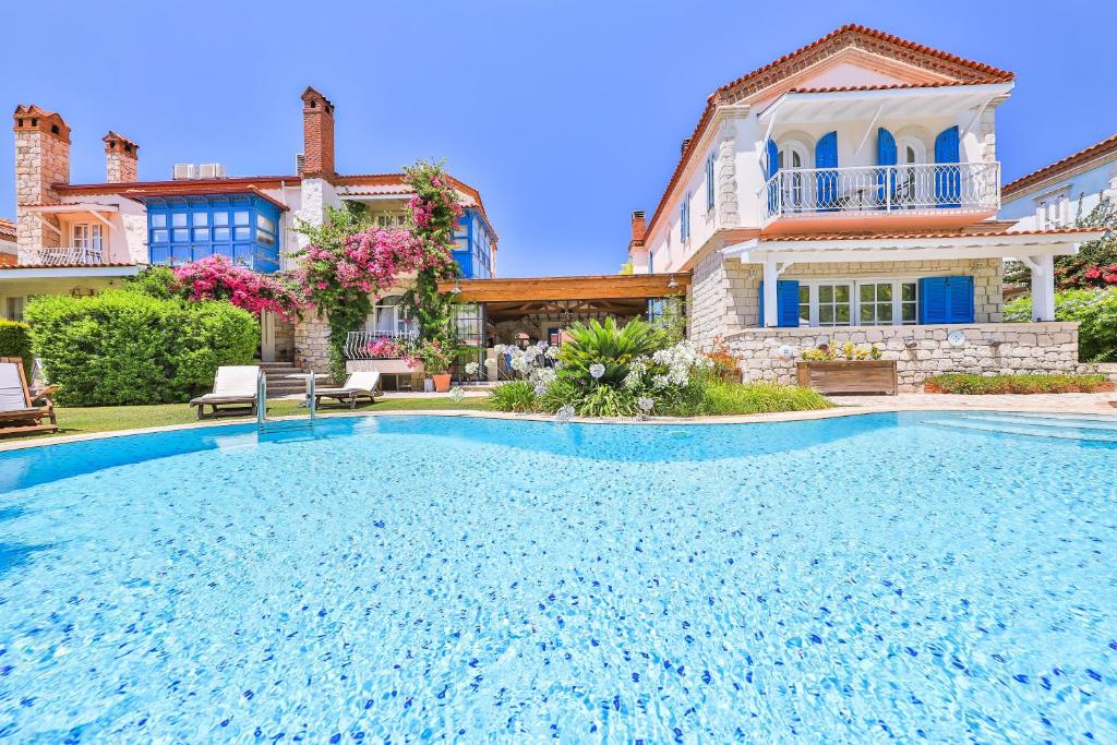 a large swimming pool in front of a house at Cumbali Konak Hotel (Adults Only +12) in Alacati