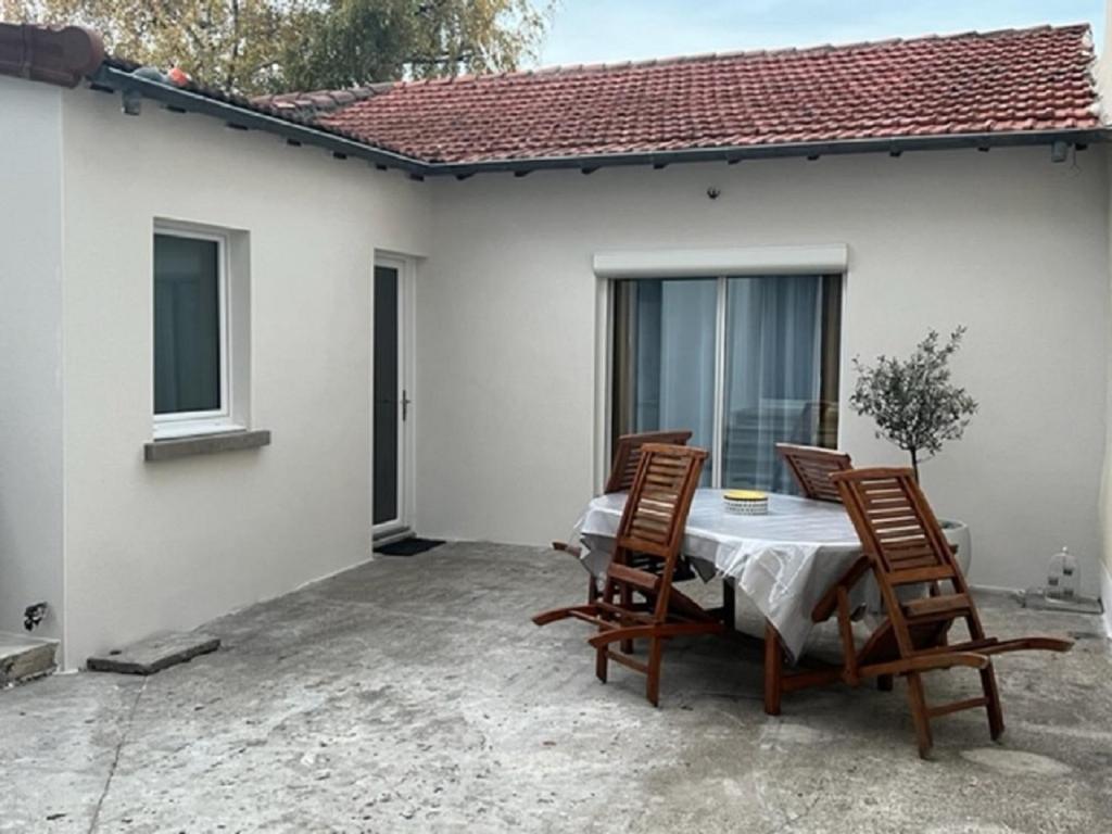 une table et des chaises sur le patio d'une maison dans l'établissement Un havre de paix en plein coeur de ville près Chu, à Clermont-Ferrand