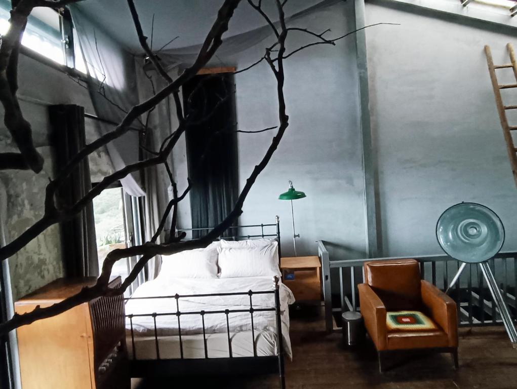 a bedroom with a bed and a tree branch in it at Yardbnb 1F in Jiufen