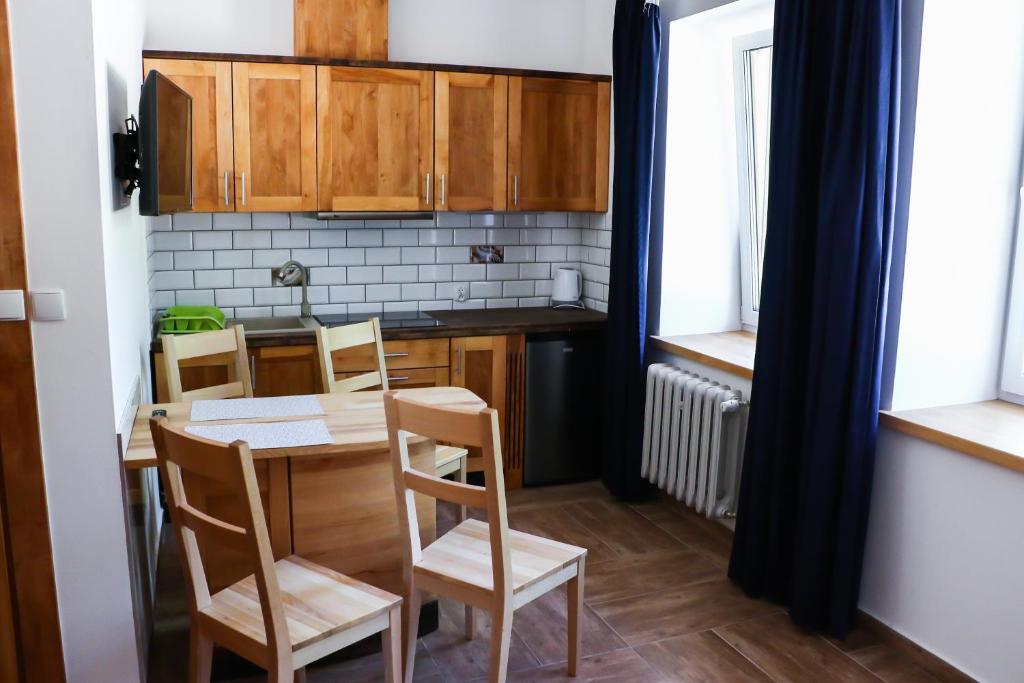 a kitchen with a table and chairs in a room at Apartamenty Willa Wądołowski in Mrągowo