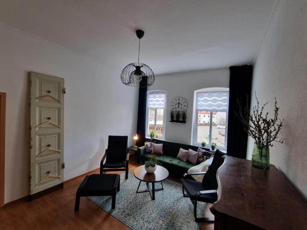 sala de estar con sofá, sillas y mesa en Gigi's Ferienwohnung Nr. 1, en Oschersleben