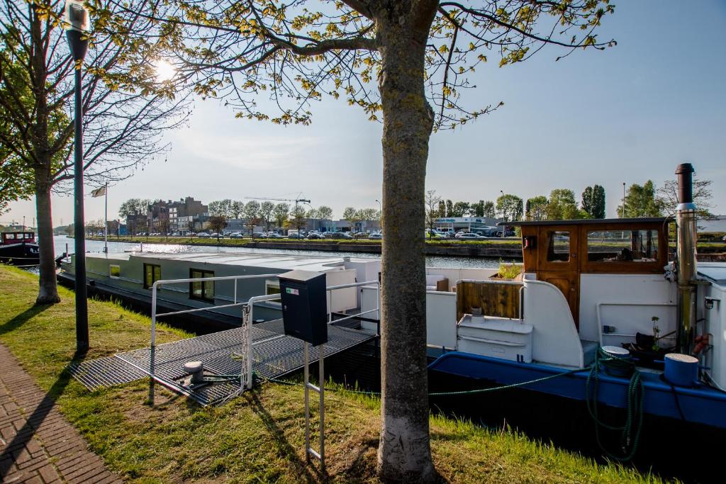 a boat is docked on a river at Houseboat Jana - with sauna and terrace in Bruges
